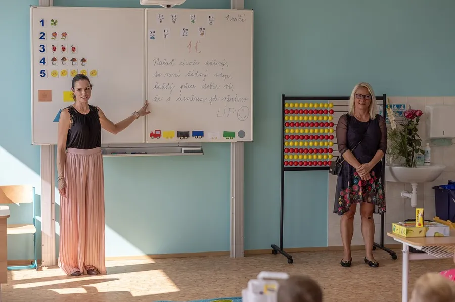 Učitelka při výuce před tabulí ve třídě