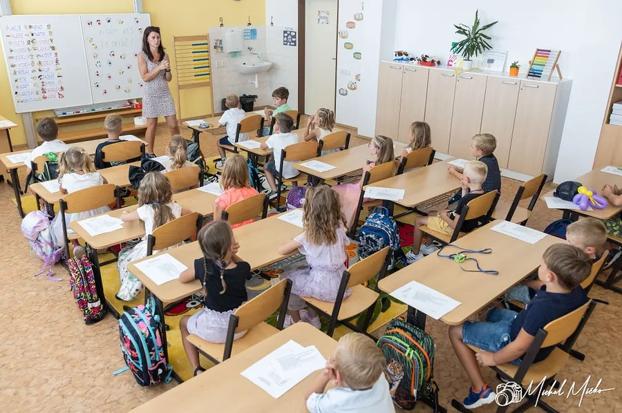 Děti sedící v lavicích v základní škole
