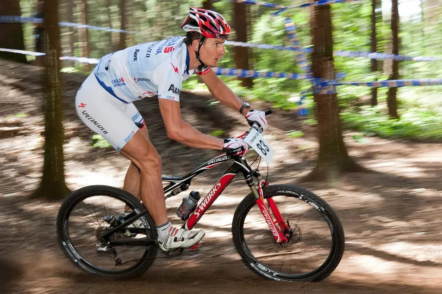 Horský cyklista při průjezdu lesní tratí